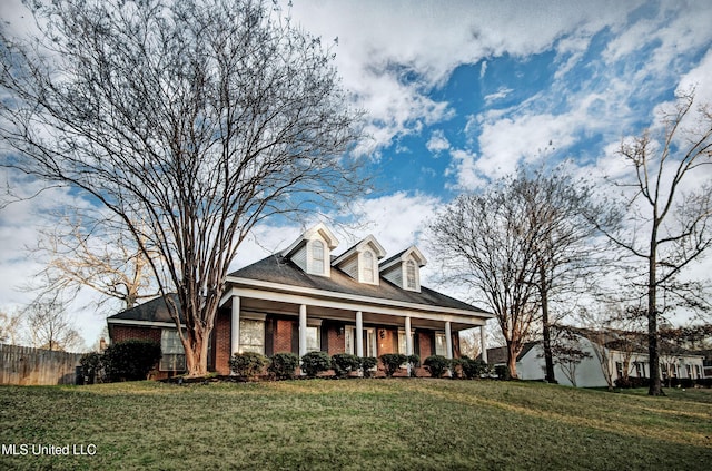 cape cod-style house with a front lawn, a porch, fence, and brick siding