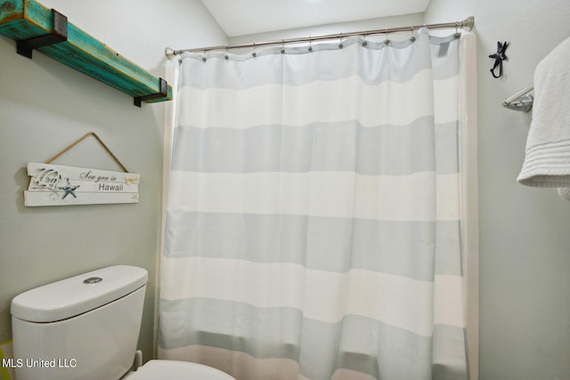 bathroom featuring a shower with curtain and toilet