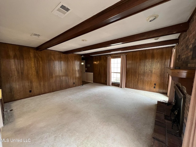 unfurnished living room with beam ceiling, light carpet, and a brick fireplace