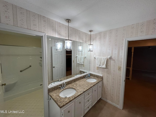 bathroom featuring vanity, a textured ceiling, a shower, and tile patterned flooring