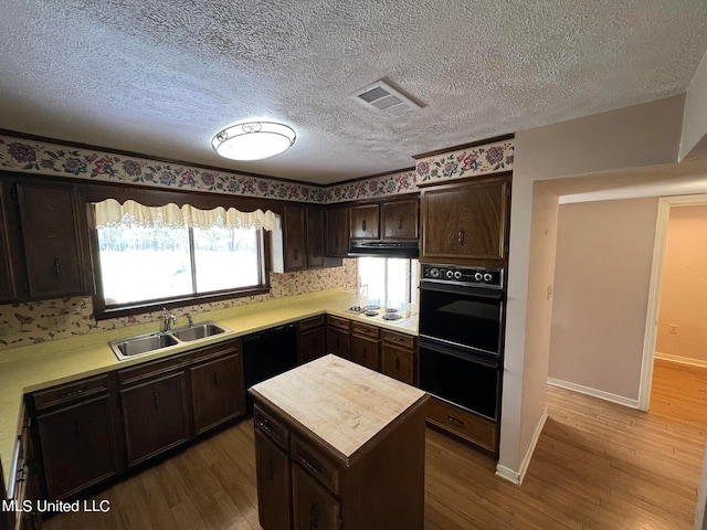 kitchen featuring a textured ceiling, wood-type flooring, sink, and black appliances