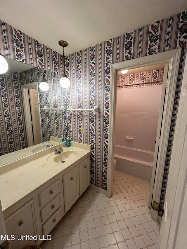 full bathroom with vanity, toilet, tile patterned floors, and washtub / shower combination