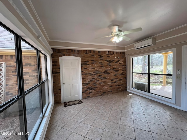 tiled empty room with brick wall, crown molding, a wall unit AC, and ceiling fan