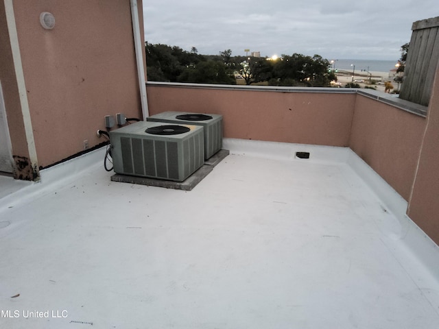 balcony featuring a water view and central AC unit