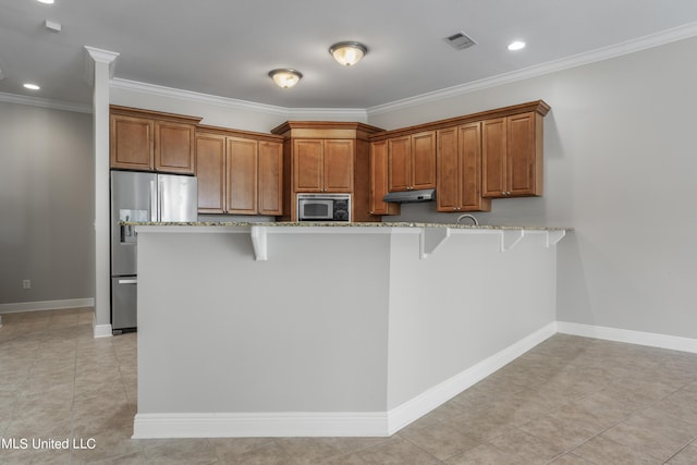 kitchen with appliances with stainless steel finishes, a breakfast bar, kitchen peninsula, crown molding, and light stone countertops