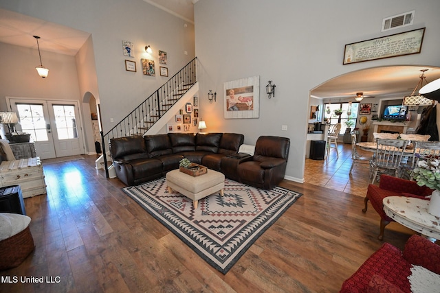 living room featuring a towering ceiling, french doors, and dark hardwood / wood-style flooring