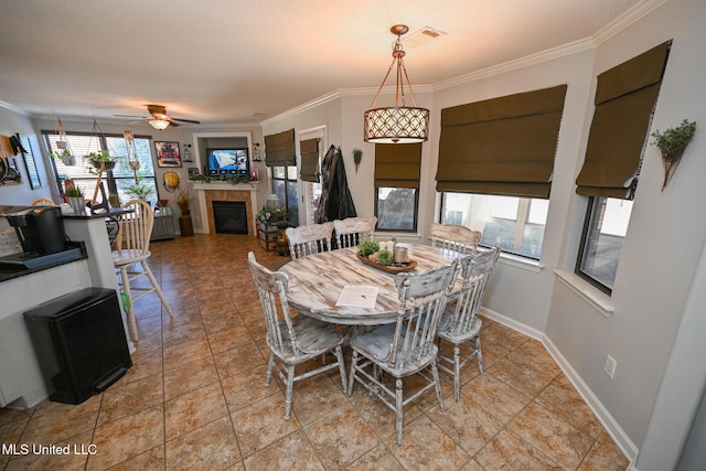 dining area featuring a textured ceiling, light tile patterned flooring, ceiling fan, and crown molding