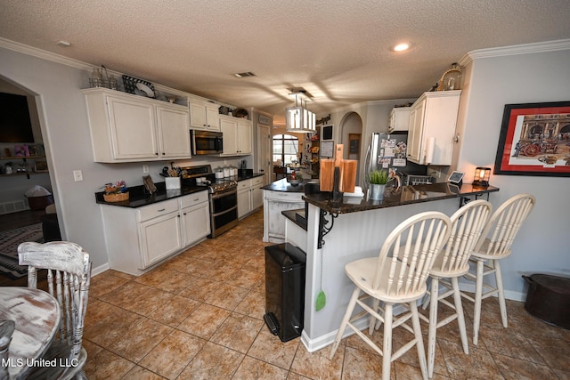 kitchen featuring stainless steel appliances, a textured ceiling, white cabinetry, kitchen peninsula, and hanging light fixtures