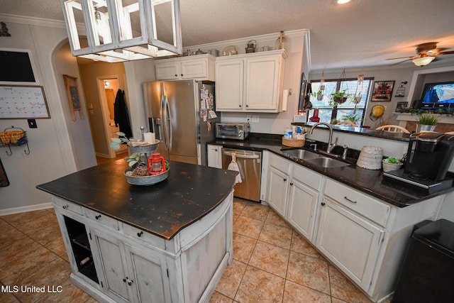 kitchen featuring stainless steel appliances, sink, white cabinetry, a textured ceiling, and ceiling fan