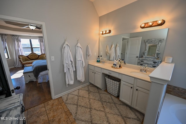 bathroom with lofted ceiling, tile patterned flooring, vanity, and ceiling fan