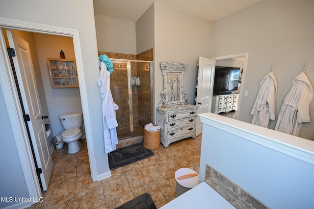 bathroom featuring toilet and a shower with shower door