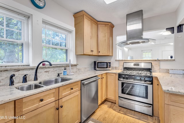 kitchen with sink, light wood-type flooring, stainless steel appliances, light brown cabinets, and ventilation hood