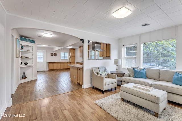 living room featuring light hardwood / wood-style flooring and ornamental molding