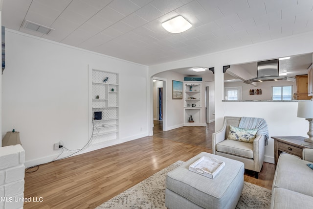 living room with crown molding and wood-type flooring