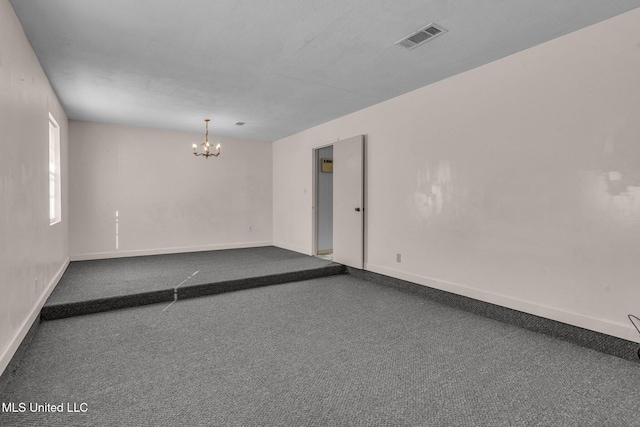 unfurnished room featuring an inviting chandelier