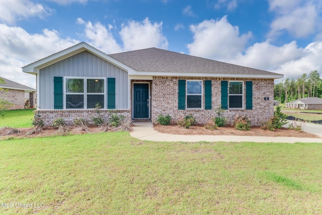 ranch-style home with roof with shingles, board and batten siding, a front lawn, and brick siding
