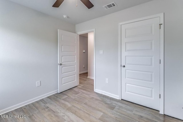 unfurnished bedroom featuring baseboards, visible vents, ceiling fan, and light wood-type flooring