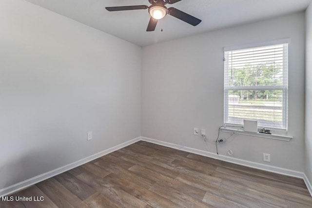 empty room with baseboards, a ceiling fan, and dark wood-style floors
