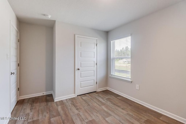 unfurnished bedroom featuring baseboards and wood finished floors