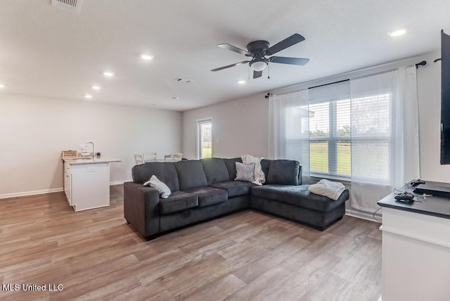 living area with recessed lighting, a ceiling fan, and light wood-style flooring