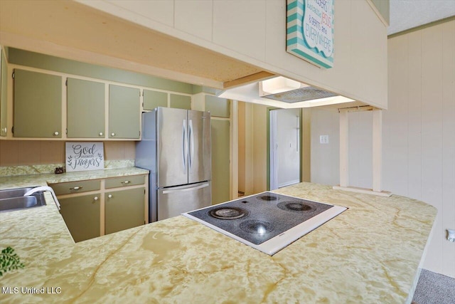 kitchen with stainless steel fridge, kitchen peninsula, sink, and white electric stovetop