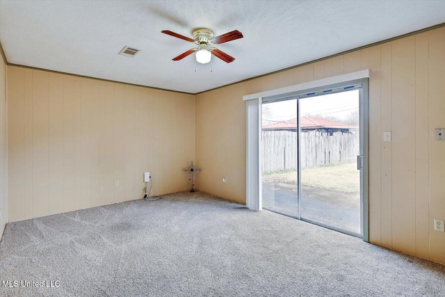 carpeted spare room with ceiling fan and a textured ceiling