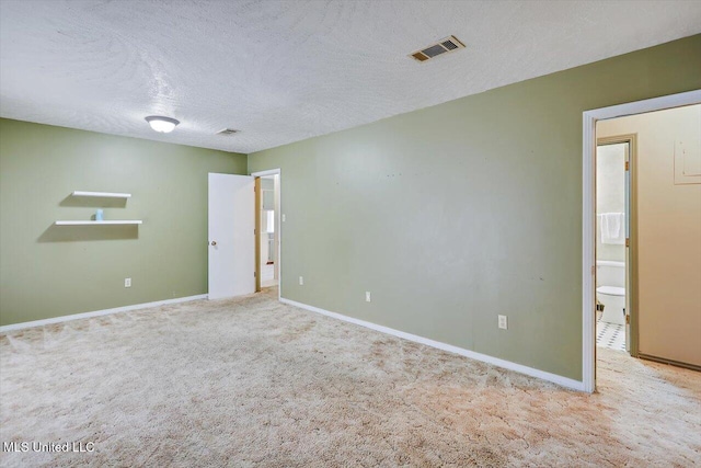 unfurnished room featuring light colored carpet and a textured ceiling