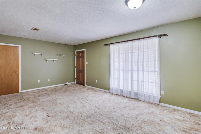 carpeted spare room featuring a textured ceiling