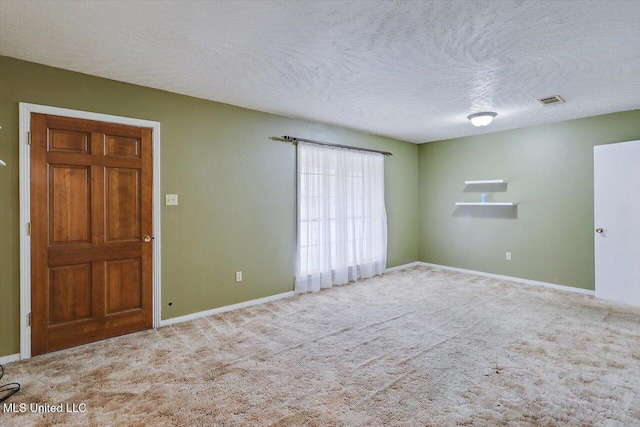 unfurnished room with a textured ceiling and carpet