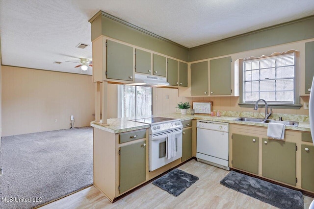 kitchen with sink, green cabinets, white appliances, kitchen peninsula, and a textured ceiling