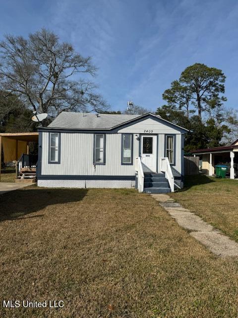 view of front facade featuring a front yard and a carport