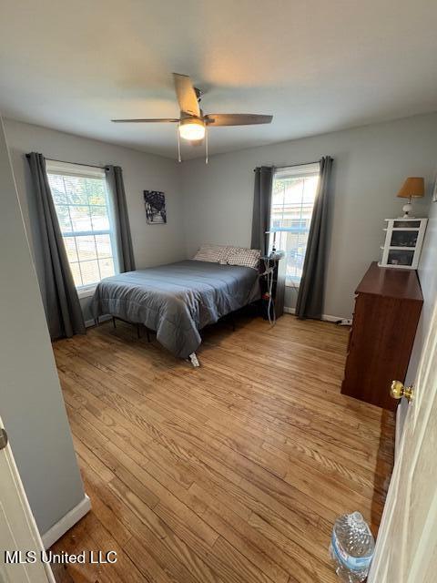 bedroom featuring multiple windows, ceiling fan, and light hardwood / wood-style flooring