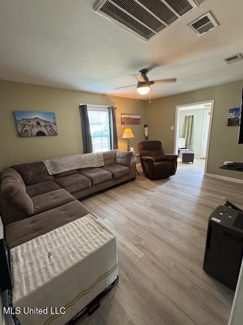 living room with ceiling fan and light hardwood / wood-style flooring