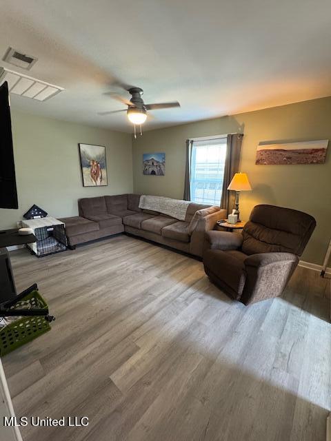 living room featuring hardwood / wood-style floors and ceiling fan