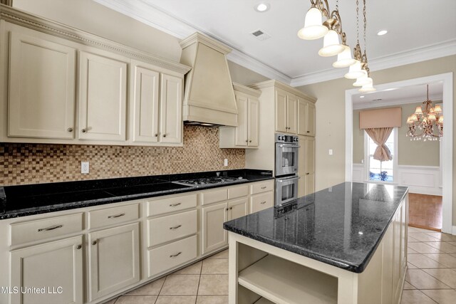 kitchen featuring pendant lighting, gas stovetop, custom range hood, stainless steel double oven, and cream cabinetry