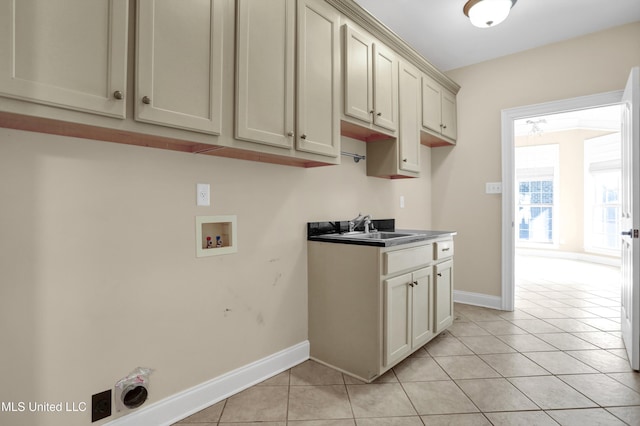 laundry room featuring cabinets, light tile patterned floors, sink, and hookup for a washing machine