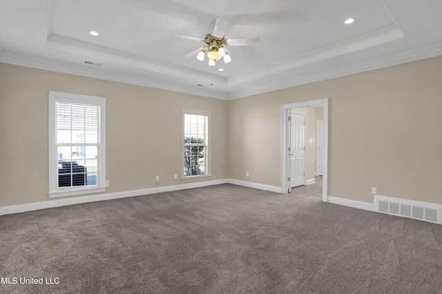 empty room featuring ceiling fan, carpet flooring, crown molding, and a tray ceiling