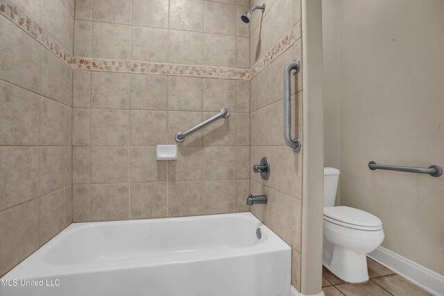 bathroom featuring tile patterned floors, toilet, and tiled shower / bath