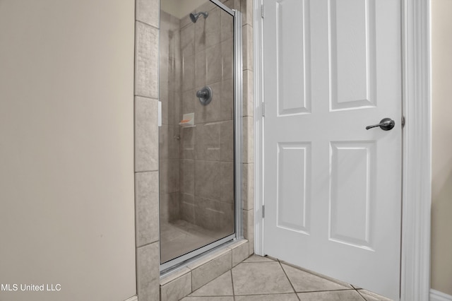 bathroom with an enclosed shower and tile patterned flooring