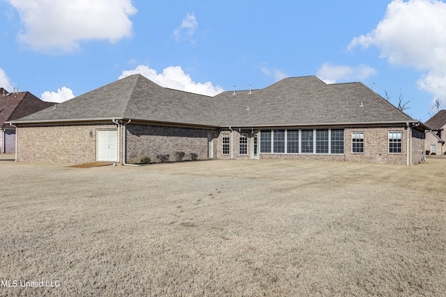 rear view of property with a lawn