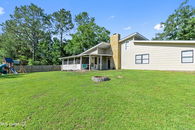 3241 Kings Bridge Rd, Moss Point, MS 39562 - rear view of property with a sunroom, a fire pit, a chimney, and a playground