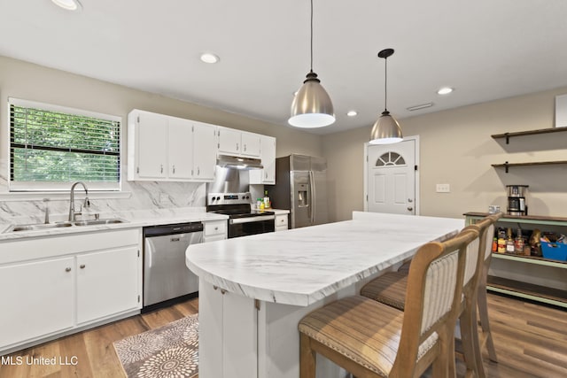 3241 Kings Bridge Rd, Moss Point, MS 39562 - kitchen featuring appliances with stainless steel finishes, a sink, under cabinet range hood, light countertops, and white cabinetry