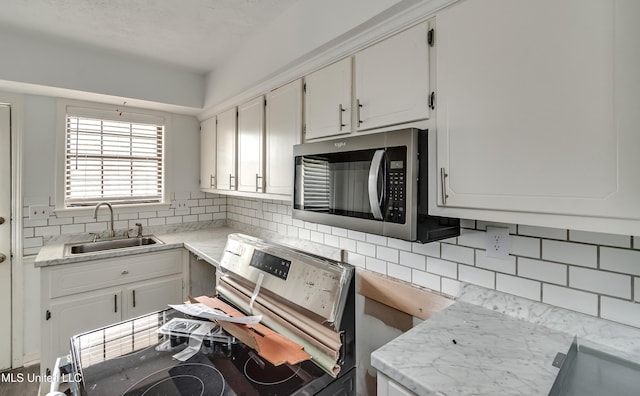 735 Wicklow Pl Unit A, Ridgeland, MS 39157 - kitchen featuring stainless steel appliances, a sink, tasteful backsplash, and white cabinets