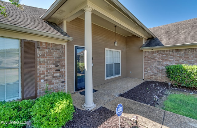 view of exterior entry with a patio area