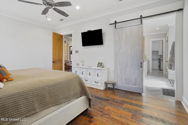 bedroom featuring dark wood-type flooring, ceiling fan, ornamental molding, and a barn door