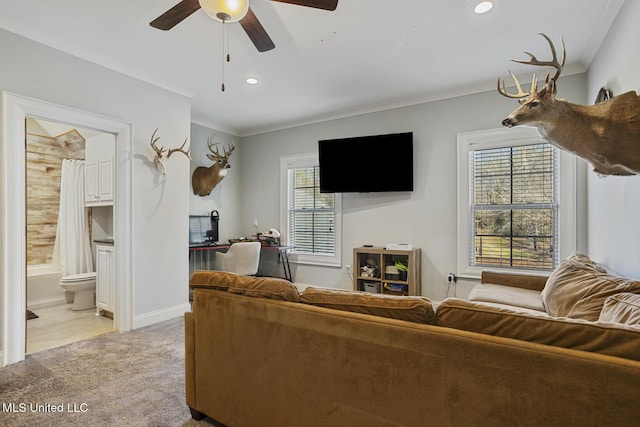 carpeted living room with crown molding, plenty of natural light, and ceiling fan