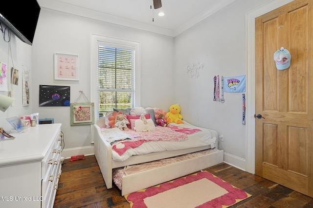 bedroom with crown molding, ceiling fan, and dark hardwood / wood-style floors