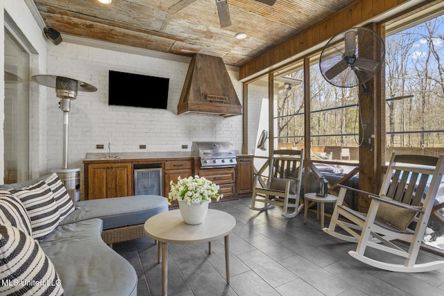 sunroom / solarium featuring wine cooler, sink, wood ceiling, and ceiling fan