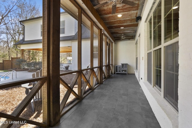 unfurnished sunroom featuring wood ceiling and ceiling fan