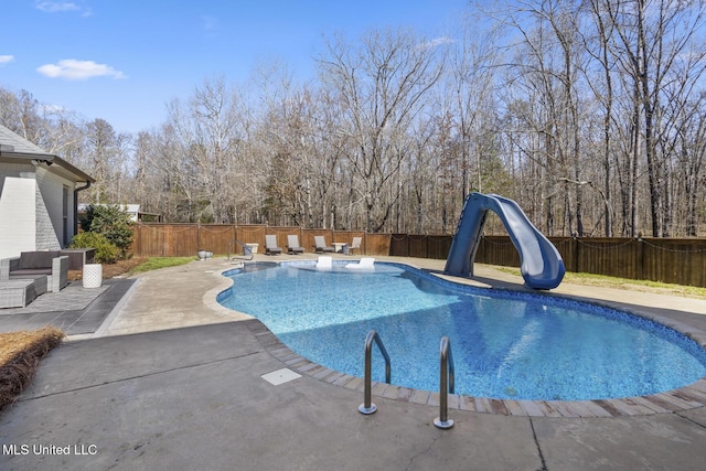 view of swimming pool with a water slide and a patio